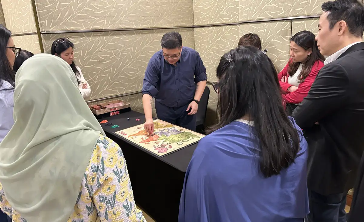 Soo Hoo guiding a multicultural team through a behaviour simulation